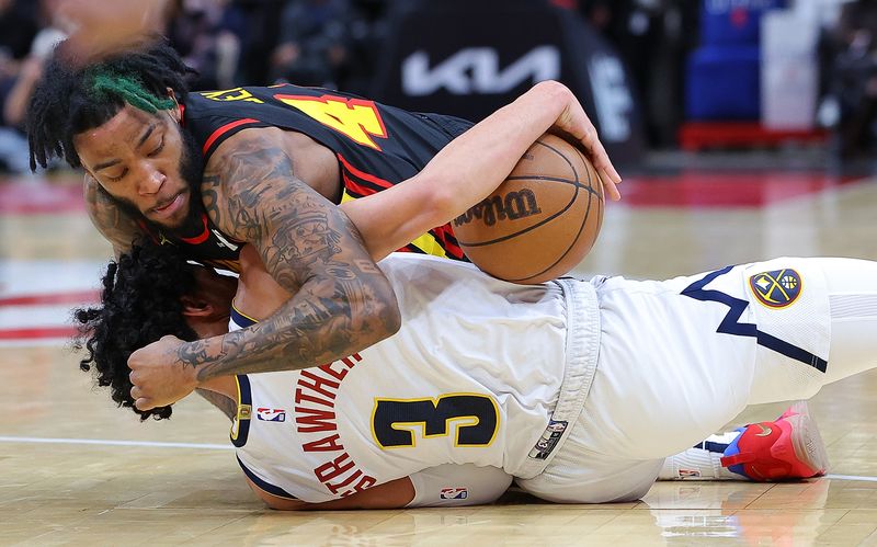 ATLANTA, GEORGIA - DECEMBER 11:  Saddiq Bey #41 of the Atlanta Hawks is charged with a foul as he battles for a loose ball against Julian Strawther #3 of the Denver Nuggets during the fourth quarter at State Farm Arena on December 11, 2023 in Atlanta, Georgia.  NOTE TO USER: User expressly acknowledges and agrees that, by downloading and/or using this photograph, user is consenting to the terms and conditions of the Getty Images License Agreement.  (Photo by Kevin C. Cox/Getty Images)