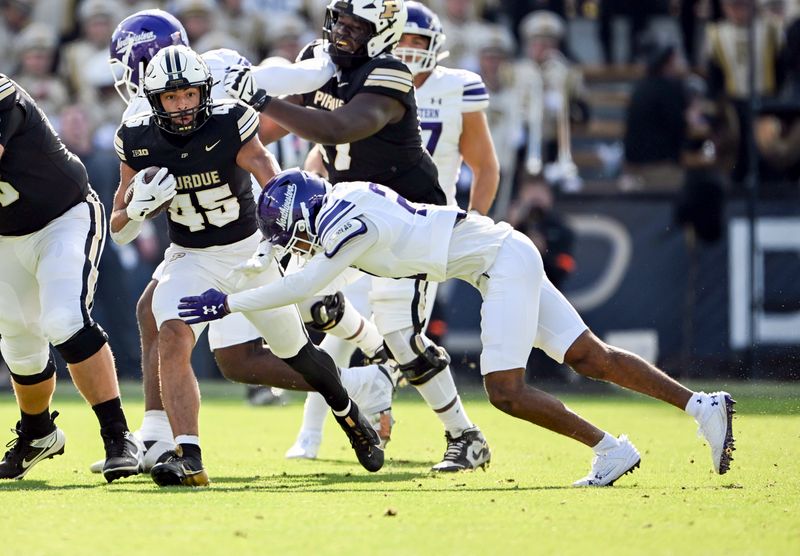 Nov 2, 2024; West Lafayette, Indiana, USA; Purdue Boilermakers running back Devin Mockobee (45) is tackled by Northwestern Wildcats defensive back Damon Walters (21) during the second quarter at Ross-Ade Stadium. Mandatory Credit: Marc Lebryk-Imagn Images