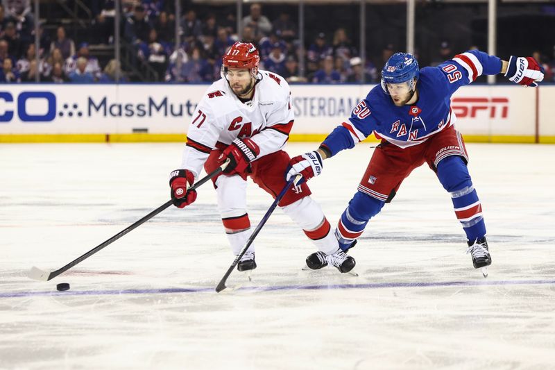 May 5, 2024; New York, New York, USA; Carolina Hurricanes defenseman Tony DeAngelo (77) and New York Rangers left wing Will Cuylle (50) battle for control of the puck in the first period in game one of the second round of the 2024 Stanley Cup Playoffs at Madison Square Garden. Mandatory Credit: Wendell Cruz-USA TODAY Sports