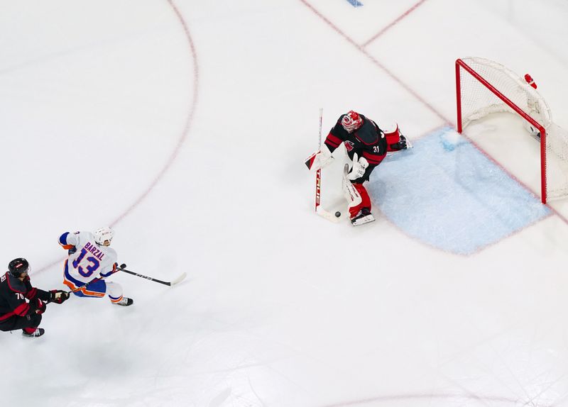 Apr 20, 2024; Raleigh, North Carolina, USA; Carolina Hurricanes goaltender Frederik Andersen (31) stops the shot attempt by New York Islanders center Mathew Barzal (13) during the first period in game one of the first round of the 2024 Stanley Cup Playoffs at PNC Arena. Mandatory Credit: James Guillory-USA TODAY Sports