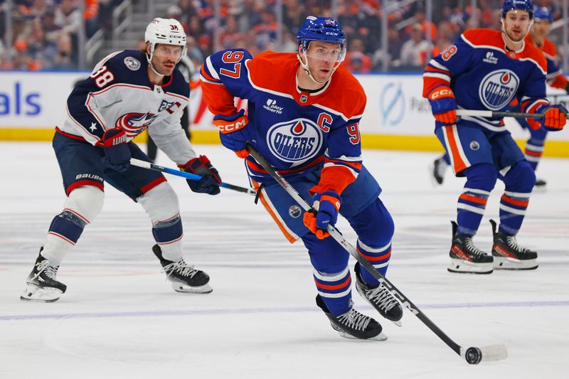 Nov 10, 2025; Edmonton, Alberta, CAN; Edmonton Oilers forward Connor McDavid (97) carries the puck in front of Columbus Blue Jackets forward Boone Jenner (38) during the first period at Rogers Place. Mandatory Credit: Perry Nelson-Imagn Images