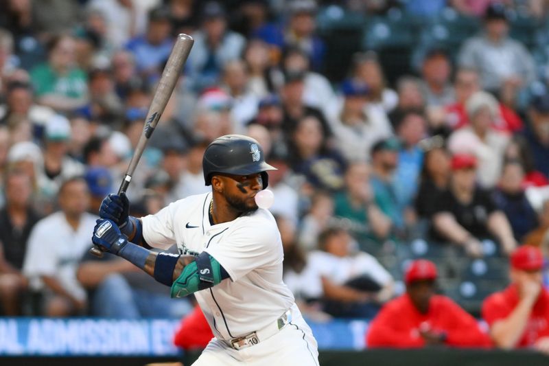 Jul 23, 2024; Seattle, Washington, USA; Seattle Mariners center fielder Victor Robles (10) blows a bubble while waiting for a pitch during the eighth inning against the Los Angeles Angels at T-Mobile Park. Mandatory Credit: Steven Bisig-USA TODAY Sports