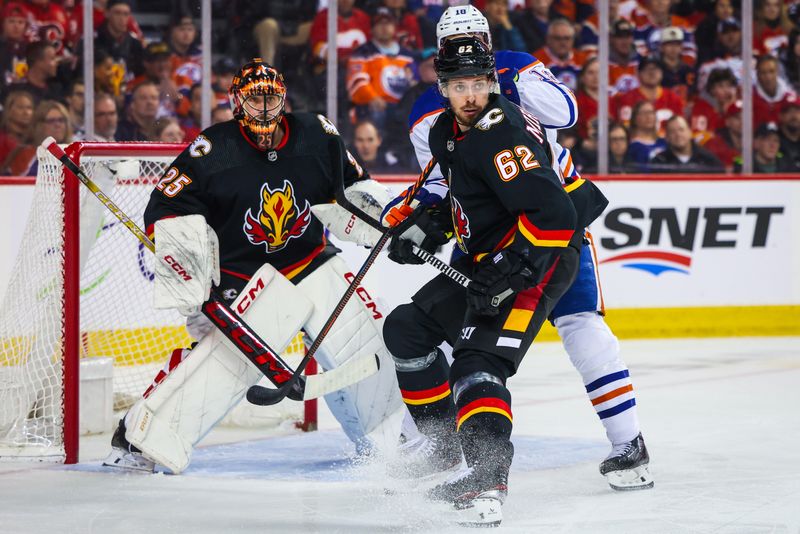 Apr 6, 2024; Calgary, Alberta, CAN; Calgary Flames defenseman Daniil Miromanov (62) and Edmonton Oilers left wing Zach Hyman (18) fights for position in front of Calgary Flames goaltender Jacob Markstrom (25) during the first period at Scotiabank Saddledome. Mandatory Credit: Sergei Belski-USA TODAY Sports