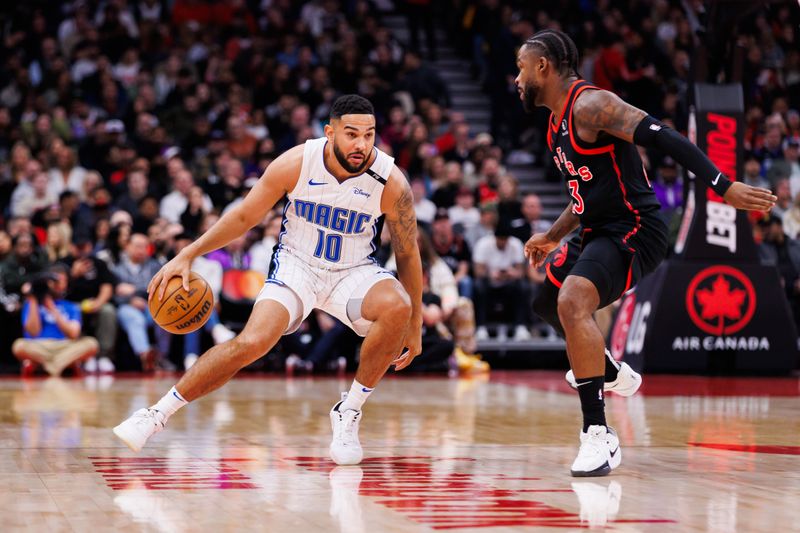 TORONTO, CANADA - JANUARY 3: Cory Joseph #10 of the Orlando Magic dribbles the ball against Jamal Shead #23 of the Toronto Raptors during first half of their NBA game at Scotiabank Arena on January 3, 2025 in Toronto, Canada. NOTE TO USER: User expressly acknowledges and agrees that, by downloading and or using this photograph, User is consenting to the terms and conditions of the Getty Images License Agreement. (Photo by Cole Burston/Getty Images)