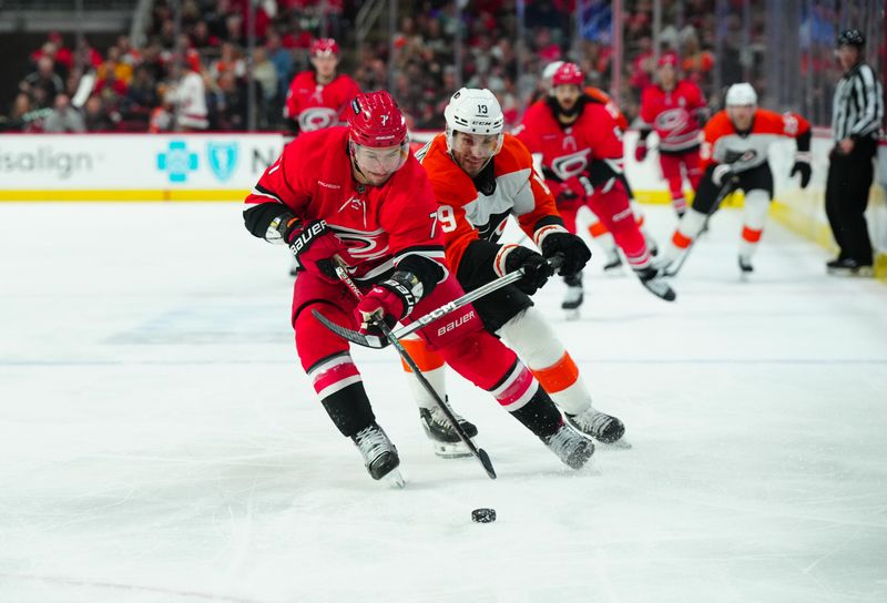 Mar 21, 2024; Raleigh, North Carolina, USA; Carolina Hurricanes defenseman Dmitry Orlov (7) tries to control the puck against Philadelphia Flyers right wing Garnet Hathaway (19) during the second period at PNC Arena. Mandatory Credit: James Guillory-USA TODAY Sports