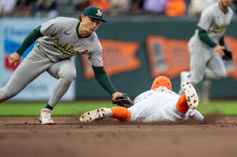 Jul 30, 2024; San Francisco, California, USA;  San Francisco Giants center fielder Heliot Ramos (17) is caught stealing second base by Oakland Athletics second baseman Zack Gelof (20) during the first inning at Oracle Park. Mandatory Credit: Neville E. Guard-USA TODAY Sports