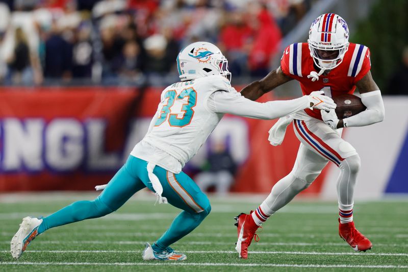 New England Patriots wide receiver DeVante Parker (1) tries to elude Miami Dolphins cornerback Eli Apple (33) during an NFL football game, Sunday, Sept. 17, 2023, in Foxborough, Mass. (AP Photo/Michael Dwyer)