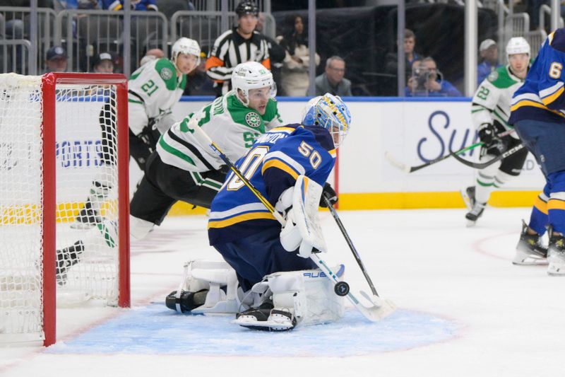 Oct 18, 2025; St. Louis, Missouri, USA; St. Louis Blues goaltender Jordan Binnington (50) makes a save against Dallas Stars center Wyatt Johnston (53) during the third period at Enterprise Center. Mandatory Credit: Jeff Le-Imagn Images