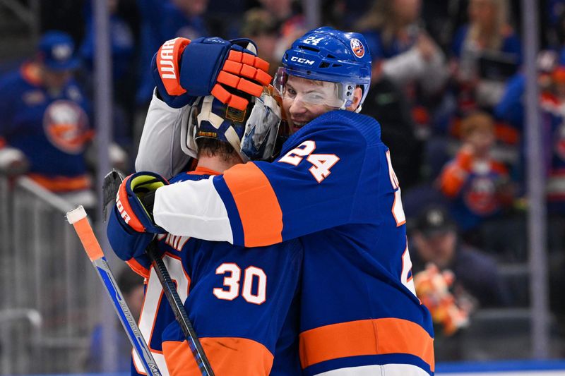 Feb 8, 2024; Elmont, New York, USA; New York Islanders defenseman Scott Mayfield (24) celebrates the 6-2 victory over Tampa Bay Lightning with New York Islanders goaltender Ilya Sorokin (30) after the game at UBS Arena. Mandatory Credit: Dennis Schneidler-USA TODAY Sports