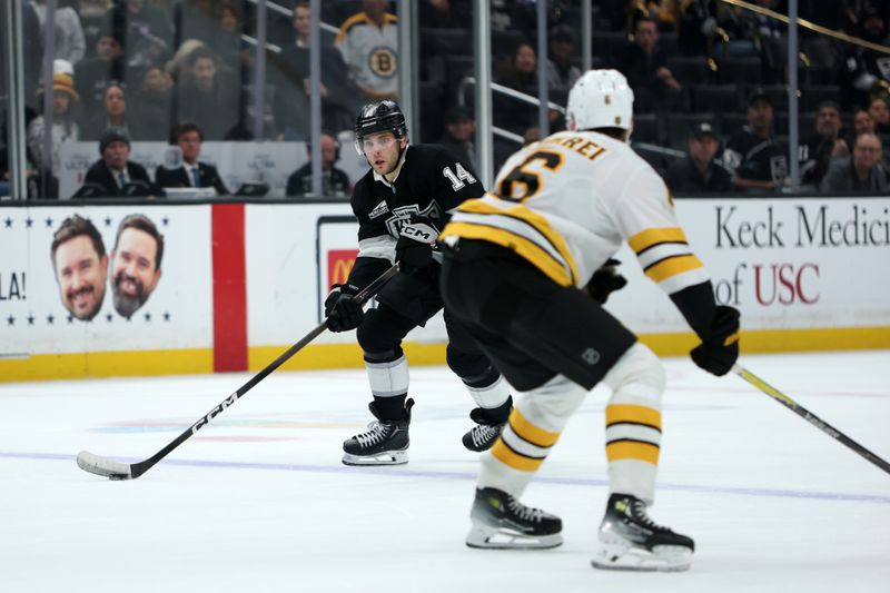 Nov 21, 2025; Los Angeles, California, USA;  Los Angeles Kings right wing Alex Laferriere (14) skates with the puck against Boston Bruins defenseman Mason Lohrei (6) during the overtime at Crypto.com Arena. Mandatory Credit: Kiyoshi Mio-Imagn Images