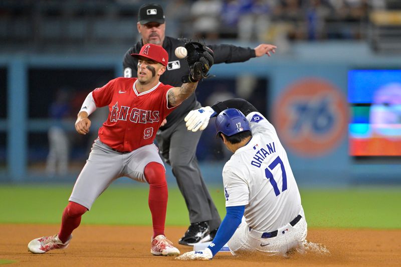 Jun 21, 2024; Los Angeles, California, USA;  Los Angeles Dodgers designated hitter Shohei Ohtani (17) is tagged out by Los Angeles Angels shortstop Zach Neto (9) on an attempted stolen base in the eighth inning at Dodger Stadium. Mandatory Credit: Jayne Kamin-Oncea-USA TODAY Sports