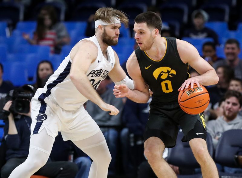 Jan 1, 2023; University Park, Pennsylvania, USA; Iowa Hawkeyes forward Filip Rebraca (0) drives the ball towards the basket as Penn State Nittany Lions forward Michael Henn (24) defends during the first half at Bryce Jordan Center. Penn State defeated Iowa 83-79. Mandatory Credit: Matthew OHaren-USA TODAY Sports