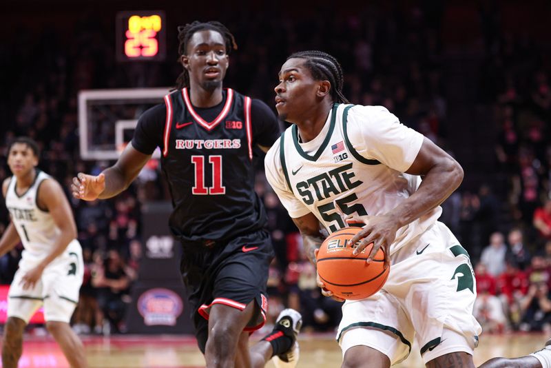 Jan 27, 2026; Piscataway, New Jersey, USA; Michigan State Spartans forward Coen Carr (55) goes to the basket against Rutgers Scarlet Knights forward Christopher Nwuli (11) during the first half at Jersey Mike's Arena. Mandatory Credit: Vincent Carchietta-Imagn Images