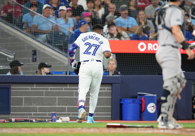 Jun 30, 2024; Toronto, Ontario, CAN; Toronto Blue Jays first base Vladimir Guerrero Jr. (27) walks towards the dugout after being hit with a pitch against the New York Yankees during the third inning at Rogers Centre. Mandatory Credit: Nick Turchiaro-USA TODAY Sports