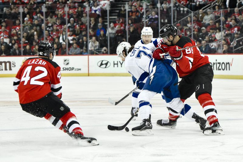 Feb 25, 2024; Newark, New Jersey, USA; Tampa Bay Lightning center Anthony Cirelli (71) tries to get past New Jersey Devils defenseman Kevin Bahl (88) and New Jersey Devils center Curtis Lazar (42) during the first period at Prudential Center. Mandatory Credit: John Jones-USA TODAY Sports