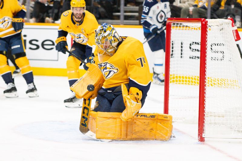 Nov 23, 2024; Nashville, Tennessee, USA;  Nashville Predators goaltender Juuse Saros (74) blocks the puck against the Winnipeg Jets during the second period at Bridgestone Arena. Mandatory Credit: Steve Roberts-Imagn Images