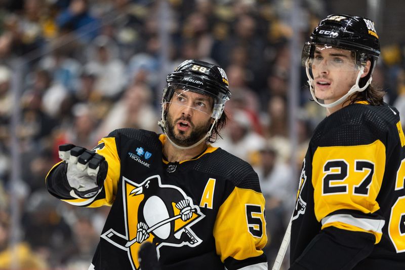 Oct 14, 2023; Pittsburgh, Pennsylvania, USA; Pittsburgh Penguins defenseman Kris Letang (58) walks with defenseman Ryan Graves (27) during a break in play against the Calgary Flames during the second period at PPG Paints Arena. Mandatory Credit: Scott Galvin-USA TODAY Sports