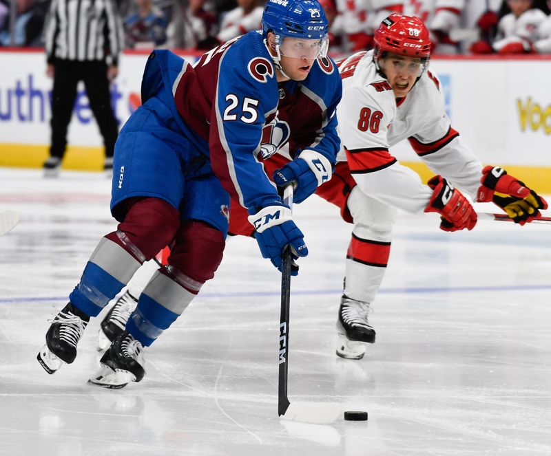 Oct 21, 2023; Denver, Colorado, USA; Colorado Avalanche right wing Logan O'Connor (25) skates the puck down ice as he looks to take a shot on goal as Carolina Hurricanes left wing Teuvo Teravainen (86) gives chase in the second period at Ball Arena. Mandatory Credit: John Leyba-USA TODAY Sports