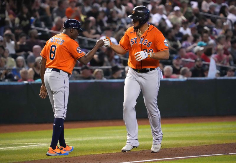 Oct 1, 2023; Phoenix, Arizona, USA; Houston Astros first baseman Jose Abreu (79) bumps fists with Houston Astros third base coach Gary Pettis (8) after hitting a home run against the Arizona Diamondbacks during the seventh inning at Chase Field. Mandatory Credit: Joe Camporeale-USA TODAY Sports