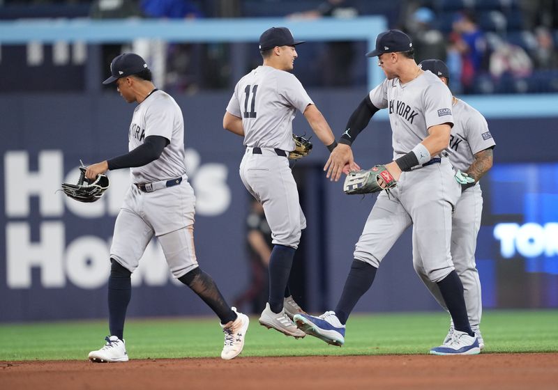 Apr 17, 2024; Toronto, Ontario, CAN; New York Yankees shortstop Anthony Volpe (11) celebrates the win with center fielder Aaron Judge (99) against the Toronto Blue Jays at the end of the ninth inning at Rogers Centre. Mandatory Credit: Nick Turchiaro-USA TODAY Sports