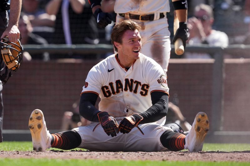 Apr 9, 2023; San Francisco, California, USA; San Francisco Giants center fielder Bryce Johnson (58) sits on the ground after scoring a run against the Kansas City Royals during the eighth inning at Oracle Park. Mandatory Credit: Darren Yamashita-USA TODAY Sports