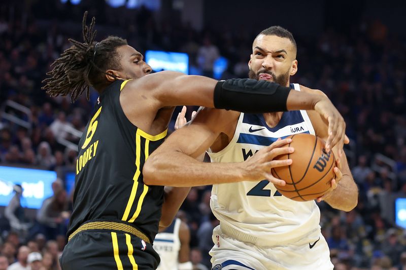 SAN FRANCISCO, CALIFORNIA - NOVEMBER 14: Rudy Gobert #27 of the Minnesota Timberwolves is guarded by Kevon Looney #5 of the Golden State Warriors at Chase Center on November 14, 2023 in San Francisco, California. NOTE TO USER: User expressly acknowledges and agrees that, by downloading and or using this photograph, User is consenting to the terms and conditions of the Getty Images License Agreement.  (Photo by Ezra Shaw/Getty Images)