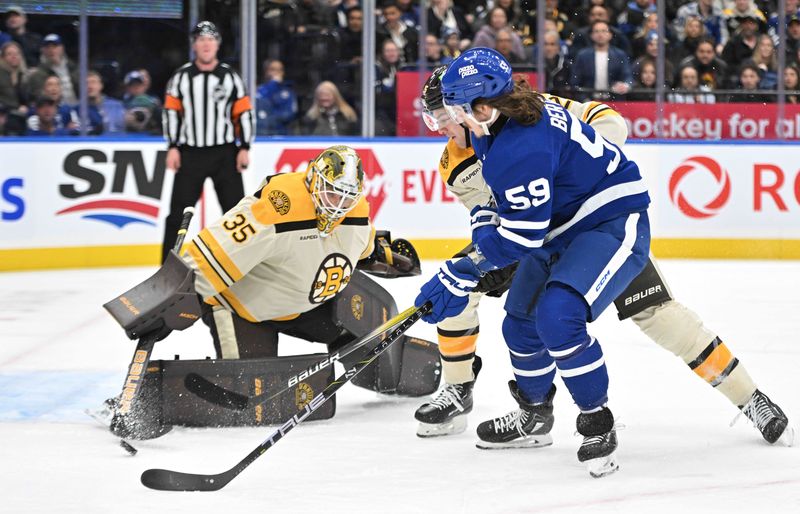 Dec 2, 2023; Toronto, Ontario, CAN; Boston Bruins goalie Linus Ullmark (35) makes a save as defenseman Brandon Carlo (25) covers Toronto Maple Leafs forward Tyler Bertuzzi (59) in the first period at Scotiabank Arena. Mandatory Credit: Dan Hamilton-USA TODAY Sports