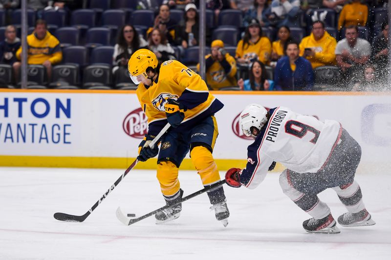 Apr 13, 2024; Nashville, Tennessee, USA; Nashville Predators right wing Luke Evangelista (77) skates as Columbus Blue Jackets defenseman Ivan Provorov (9) pokes at the puck during the first period at Bridgestone Arena. Mandatory Credit: Steve Roberts-USA TODAY Sports