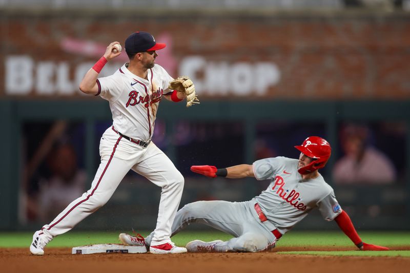 Aug 21, 2024; Atlanta, Georgia, USA; Atlanta Braves second baseman Whit Merrifield (15) turns a double play over Philadelphia Phillies shortstop Trea Turner (7) in the ninth inning at Truist Park. Mandatory Credit: Brett Davis-USA TODAY Sports
