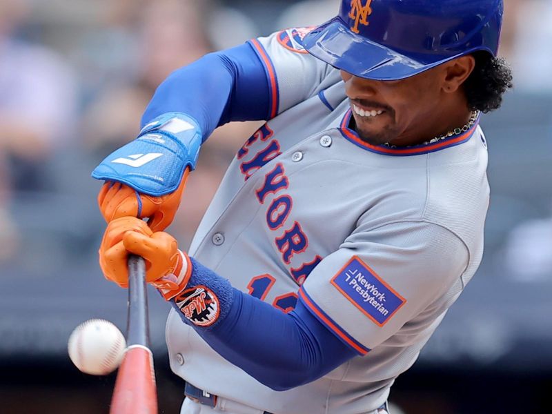 May 17, 2025; Bronx, New York, USA; New York Mets shortstop Francisco Lindor (12) hits a game winning RBI sacrifice fly against the New York Yankees during the ninth inning at Yankee Stadium. Mandatory Credit: Brad Penner-Imagn Images