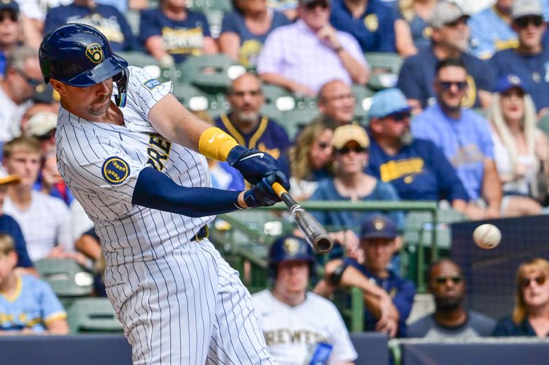 Sep 8, 2024; Milwaukee, Wisconsin, USA; Milwaukee Brewers designated hitter Rhys Hoskins (12) hits a single to drive in a run in the first inning against the Colorado Rockies at American Family Field. Mandatory Credit: Benny Sieu-Imagn Images