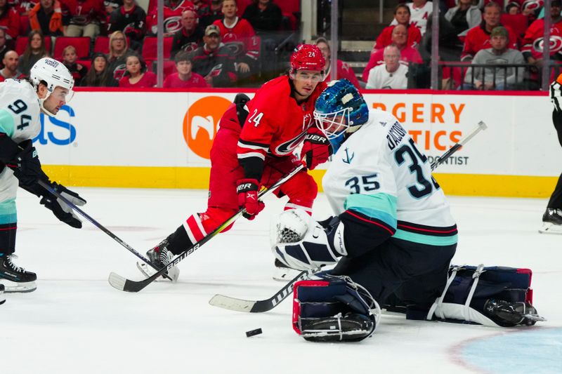 Oct 26, 2023; Raleigh, North Carolina, USA; Carolina Hurricanes center Seth Jarvis (24) scoring attempt is stopped by Seattle Kraken goaltender Joey Daccord (35) during the first period at PNC Arena. Mandatory Credit: James Guillory-USA TODAY Sports