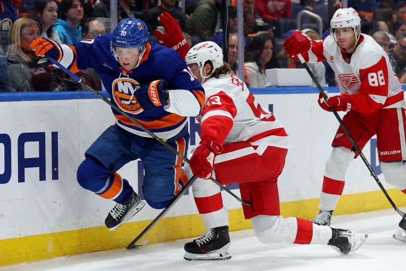 Oct 22, 2024; Elmont, New York, USA; Detroit Red Wings defenseman Moritz Seider (53) trips New York Islanders right wing Simon Holmstrom (10) during the second period at UBS Arena. Mandatory Credit: Brad Penner-Imagn Images