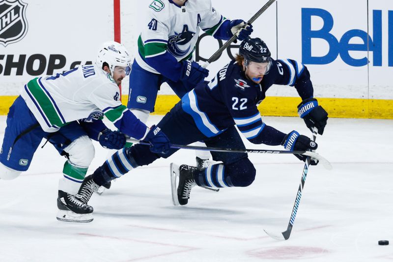 Apr 18, 2024; Winnipeg, Manitoba, CAN;  Winnipeg Jets forward Mason Appleton (22) wards off the check of Vancouver Canucks forward Conor Garland (8) during the third period at Canada Life Centre. Mandatory Credit: Terrence Lee-USA TODAY Sports