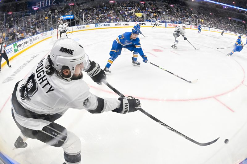 Oct 21, 2025; St. Louis, Missouri, USA; Los Angeles Kings defenseman Drew Doughty (8) clears the puck past St. Louis Blues center Nick Bjugstad (77) during the second period at Enterprise Center. Mandatory Credit: Jeff Curry-Imagn Images