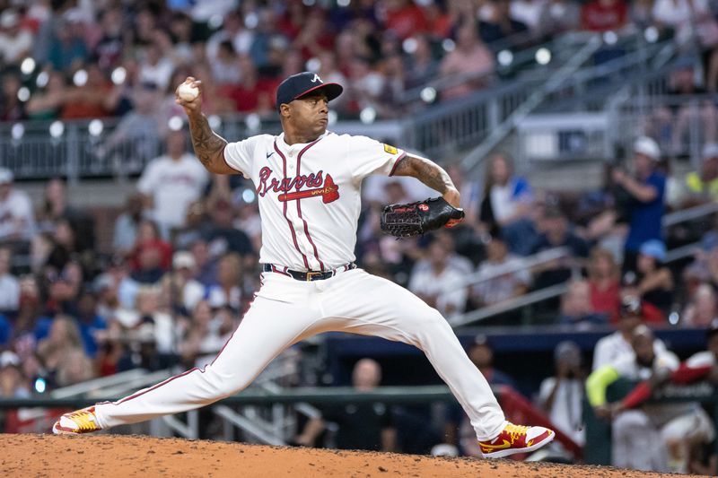 Aug 22, 2024; Cumberland, Georgia, USA; Atlanta Braves pitcher Raisel Iglesias (26) pitches the ball against Philadelphia Phillies during the ninth inning at Truist Park. Mandatory Credit: Jordan Godfree-USA TODAY Sports