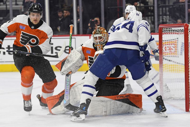 Jan 7, 2025; Philadelphia, Pennsylvania, USA; Philadelphia Flyers goaltender Ivan Fedotov (82) and defenseman Travis Sanheim (6) battle against Toronto Maple Leafs center David Kampf (64) during the second period at Wells Fargo Center. Mandatory Credit: Eric Hartline-Imagn Images