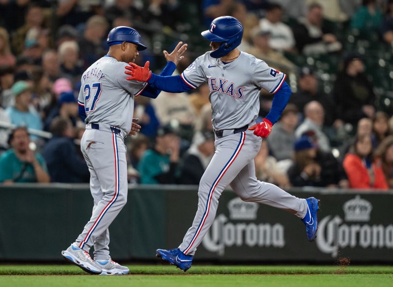 Sep 13, 2024; Seattle, Washington, USA;  Texas Rangers centerfielder Wyatt Langford (36) is congratulated by 	hird base coach Tony Beasley after hitting a solo home run during the fifth inning against the Seattle Mariners at T-Mobile Park. Mandatory Credit: Stephen Brashear-Imagn Images