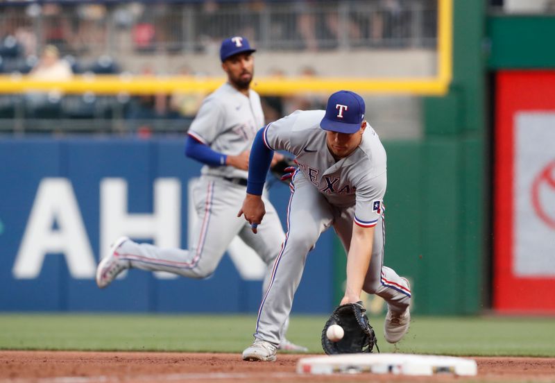 May 22, 2023; Pittsburgh, Pennsylvania, USA;  Texas Rangers first baseman Nathaniel Lowe (30) fields a ground ball for an out against Pittsburgh Pirates first baseman Carlos Santana (not pictured) during the sixth inning at PNC Park. Mandatory Credit: Charles LeClaire-USA TODAY Sports