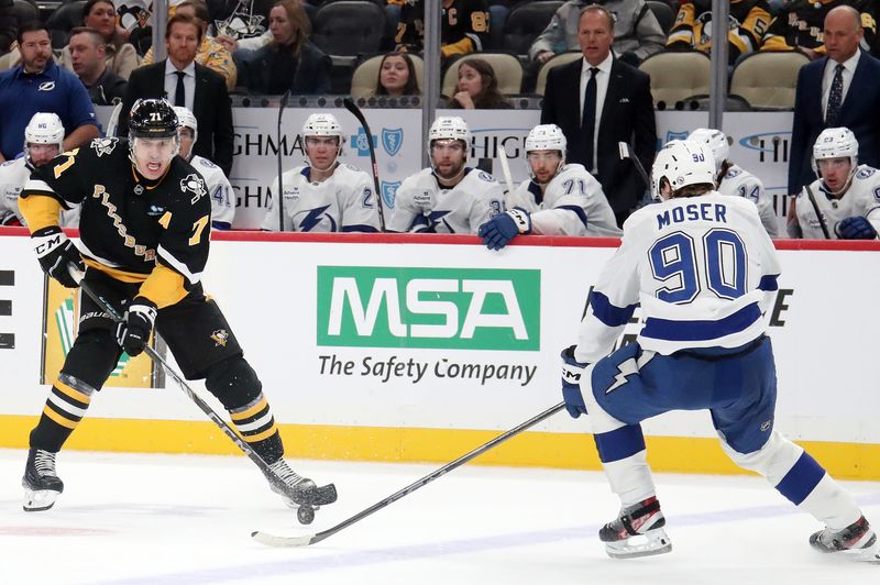 Nov 19, 2024; Pittsburgh, Pennsylvania, USA;  Pittsburgh Penguins center Evgeni Malkin (71) skates up ice with the puck as Tampa Bay Lightning defenseman J.J. Moser (90) defends during the third period at PPG Paints Arena. Mandatory Credit: Charles LeClaire-Imagn Images