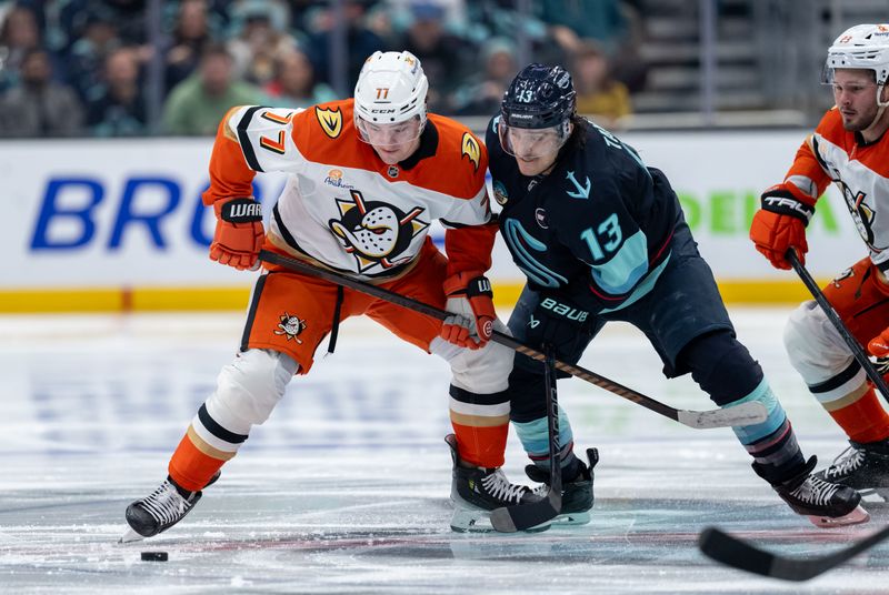 Jan 28, 2025; Seattle, Washington, USA;  Anaheim Ducks forward Frank Vatrano (77) and Seattle Kraken forward Brandon Tanev (13) battle for the puck during the second period at Climate Pledge Arena. Mandatory Credit: Stephen Brashear-Imagn Images