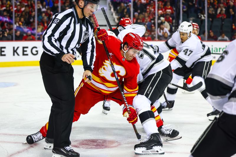 Nov 11, 2024; Calgary, Alberta, CAN; Calgary Flames center Kevin Rooney (21) face off for the puck against the Los Angeles Kings during the first period at Scotiabank Saddledome. Mandatory Credit: Sergei Belski-Imagn Images