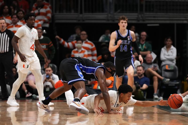 Feb 6, 2023; Coral Gables, Florida, USA; Miami Hurricanes guard Nijel Pack (24) reaches for the ball under Duke Blue Devils guard Jaylen Blakes (2) during the second half at Watsco Center. Mandatory Credit: Jasen Vinlove-USA TODAY Sports