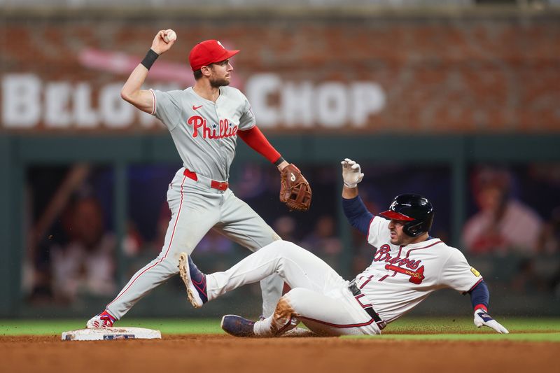 Aug 21, 2024; Atlanta, Georgia, USA; Philadelphia Phillies shortstop Trea Turner (7) turns a double play over Atlanta Braves right fielder Ramon Laureano (18) in the sixth inning at Truist Park. Mandatory Credit: Brett Davis-USA TODAY Sports