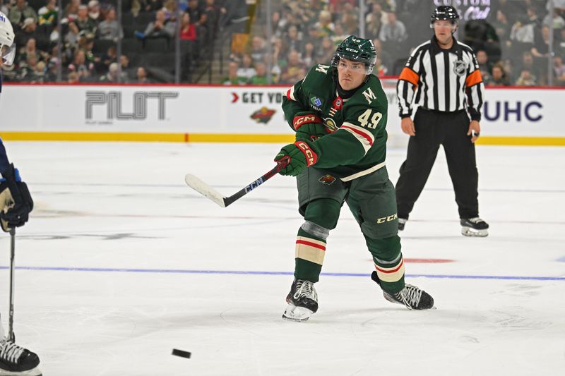 Sep 27, 2024; Saint Paul, Minnesota, USA;  Minnesota Wild defenseman Jack Peart (49) throws a pass off the back wall that would lead to an assist against the Winnipeg Jets during the second period at Xcel Energy Center. Mandatory Credit: Nick Wosika-Imagn Images

