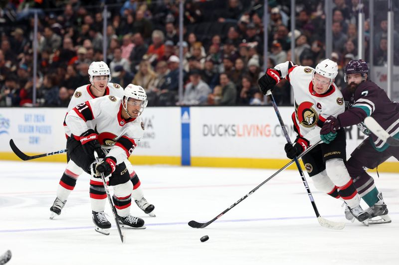 Mar 6, 2024; Anaheim, California, USA;  Ottawa Senators right wing Mathieu Joseph (21) and left wing Brady Tkachuk (7) fight for the puck against Anaheim Ducks defenseman Radko Gudas (7) during the third period at Honda Center. Mandatory Credit: Kiyoshi Mio-USA TODAY Sports