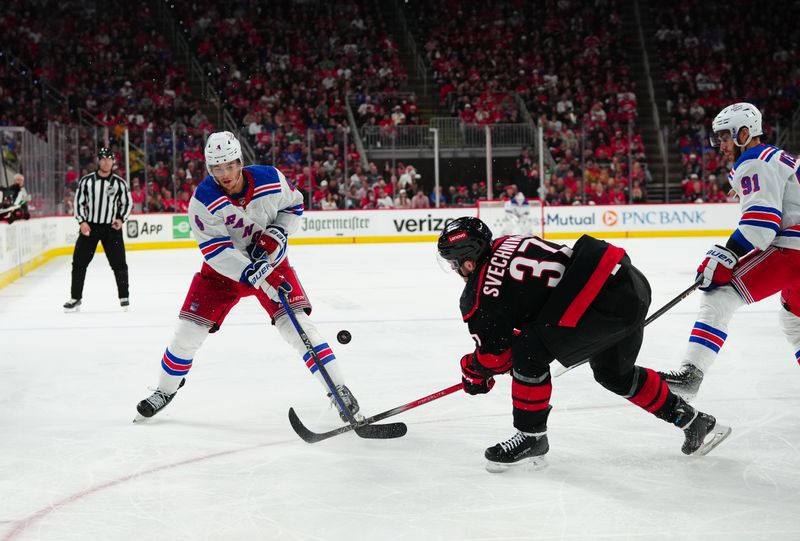 May 16, 2024; Raleigh, North Carolina, USA; Carolina Hurricanes right wing Andrei Svechnikov (37) blocks the shot attempt by New York Rangers defenseman Braden Schneider (4) during the second period in game six of the second round of the 2024 Stanley Cup Playoffs at PNC Arena. Mandatory Credit: James Guillory-USA TODAY Sports