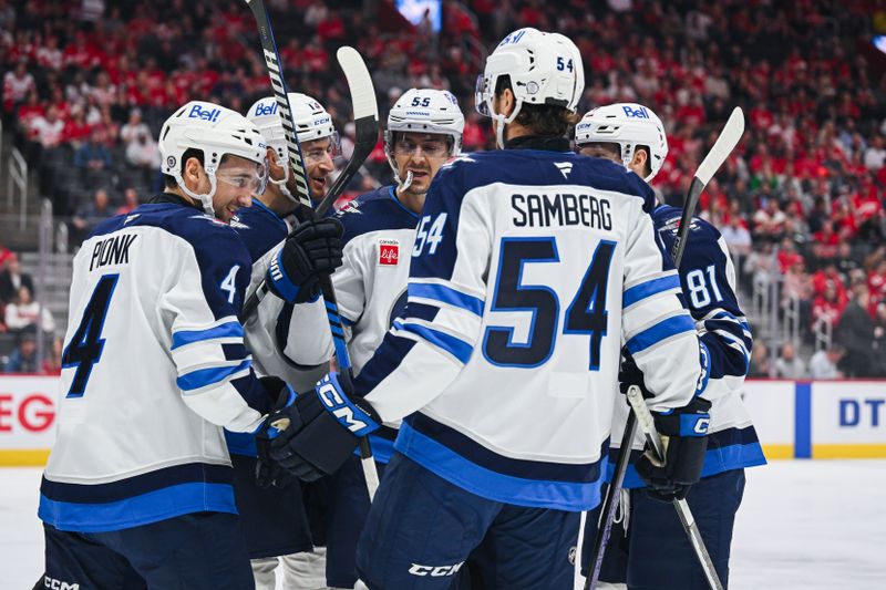 Oct 30, 2024; Detroit, Michigan, USA; Winnipeg Jets defenseman Neal Pink (4) celebrates his goal with teammates during the first period against the Detroit Red Wings at Little Caesars Arena. Mandatory Credit: Tim Fuller-Imagn Images