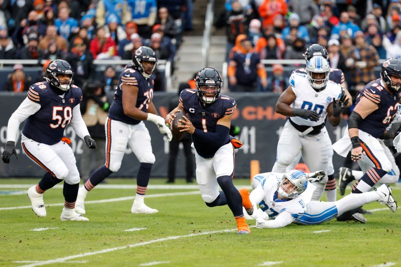 Chicago Bears quarterback Justin Fields (1) runs with the ball past Detroit Lions defensive end Aidan Hutchinson (97) during the first half of an NFL football game, Sunday, Dec. 10, 2023, in Chicago. (AP Photo/Kamil Krzaczynski)