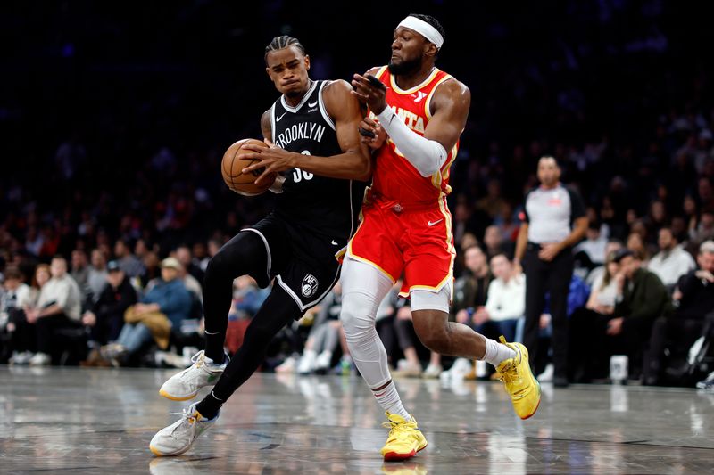 NEW YORK, NEW YORK - MARCH 02: Nic Claxton #33 of the Brooklyn Nets dribbles against Bruno Fernando #24 of the Atlanta Hawks during the first half at Barclays Center on March 02, 2024 in the Brooklyn borough of New York City. NOTE TO USER: User expressly acknowledges and agrees that, by downloading and or using this photograph, User is consenting to the terms and conditions of the Getty Images License Agreement. (Photo by Sarah Stier/Getty Images)